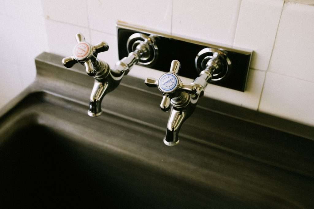 Close-Up Shot of Two Silver Faucets in the Sink